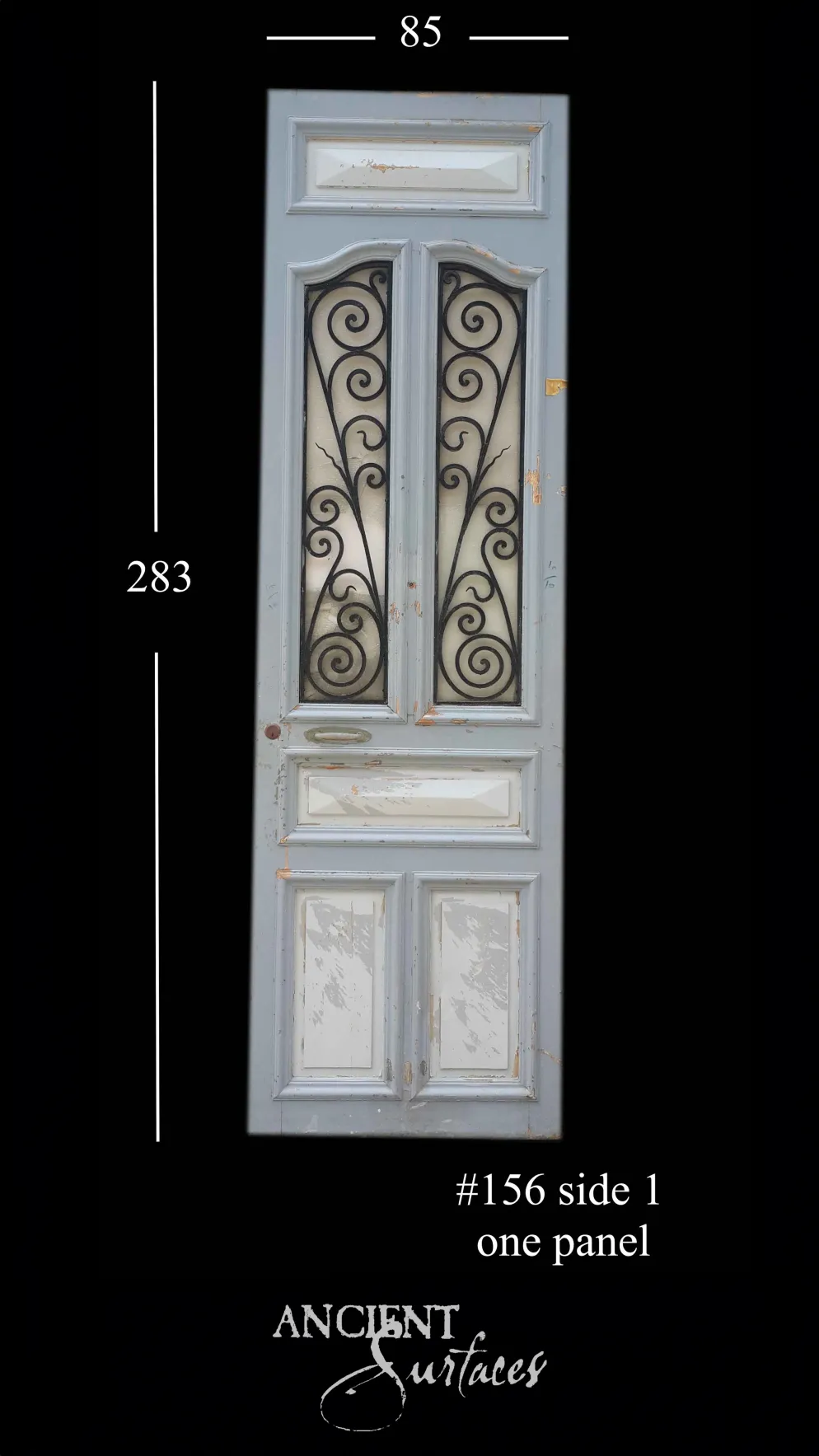 Tall pale-blue reclaimed antique door with ornate wrought-iron scrollwork over frosted glass