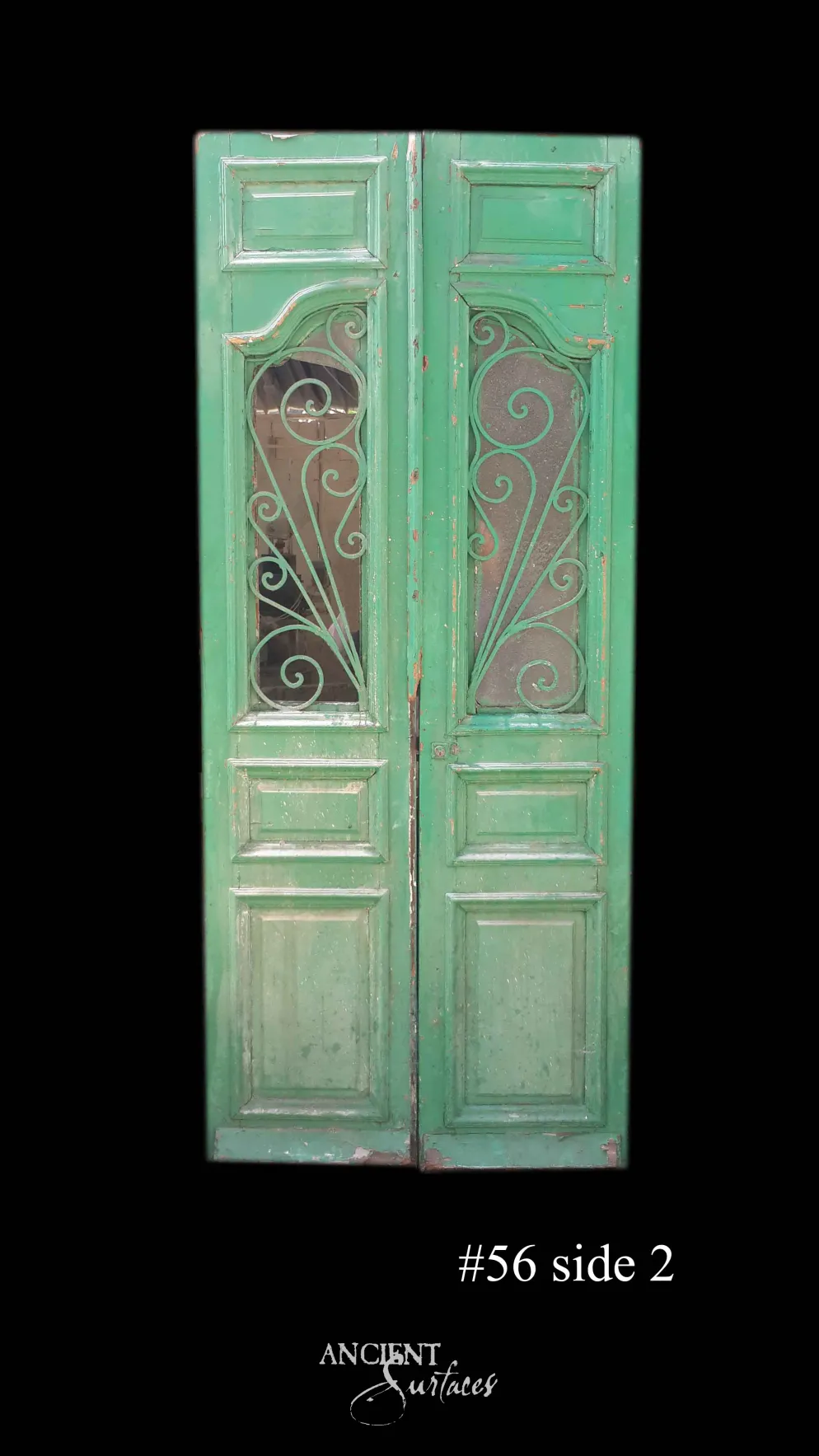 Emerald-green reclaimed antique double door with fan-shaped wrought-iron scroll grilles over glass